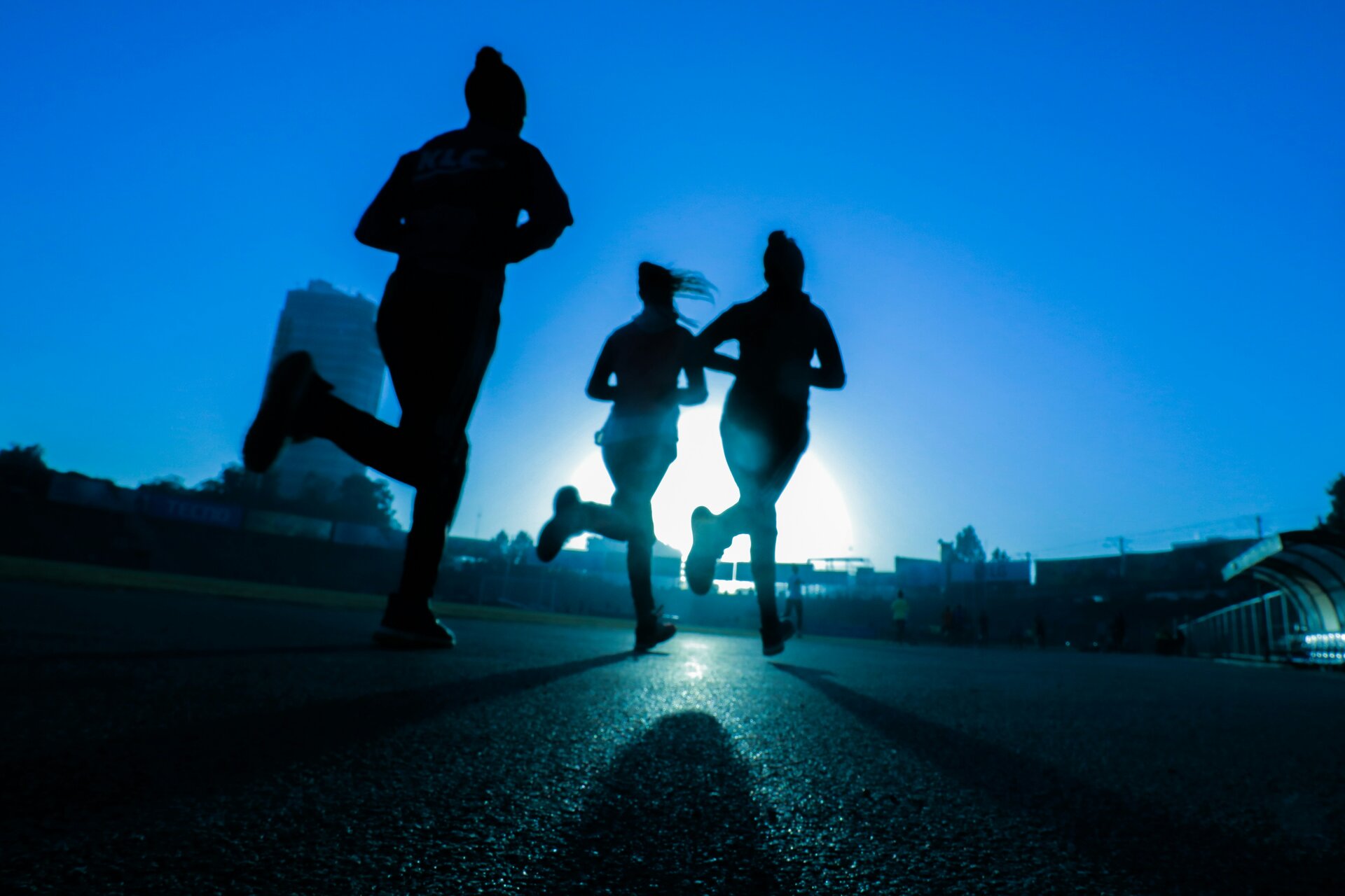 Silhouetted people moving through a blue-lit space